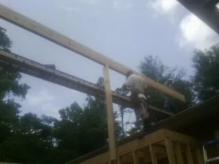 Carpenter setting a ridge beam over a new addition frame — Ice Dam Removal by Roofing Brothers in Cashiers