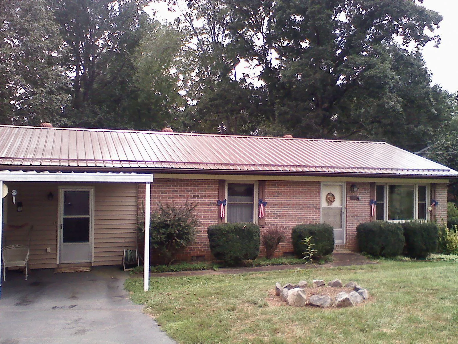 Bronze metal roof and carport on a brick ranch home — Roof Repair work by our crew in Cashiers