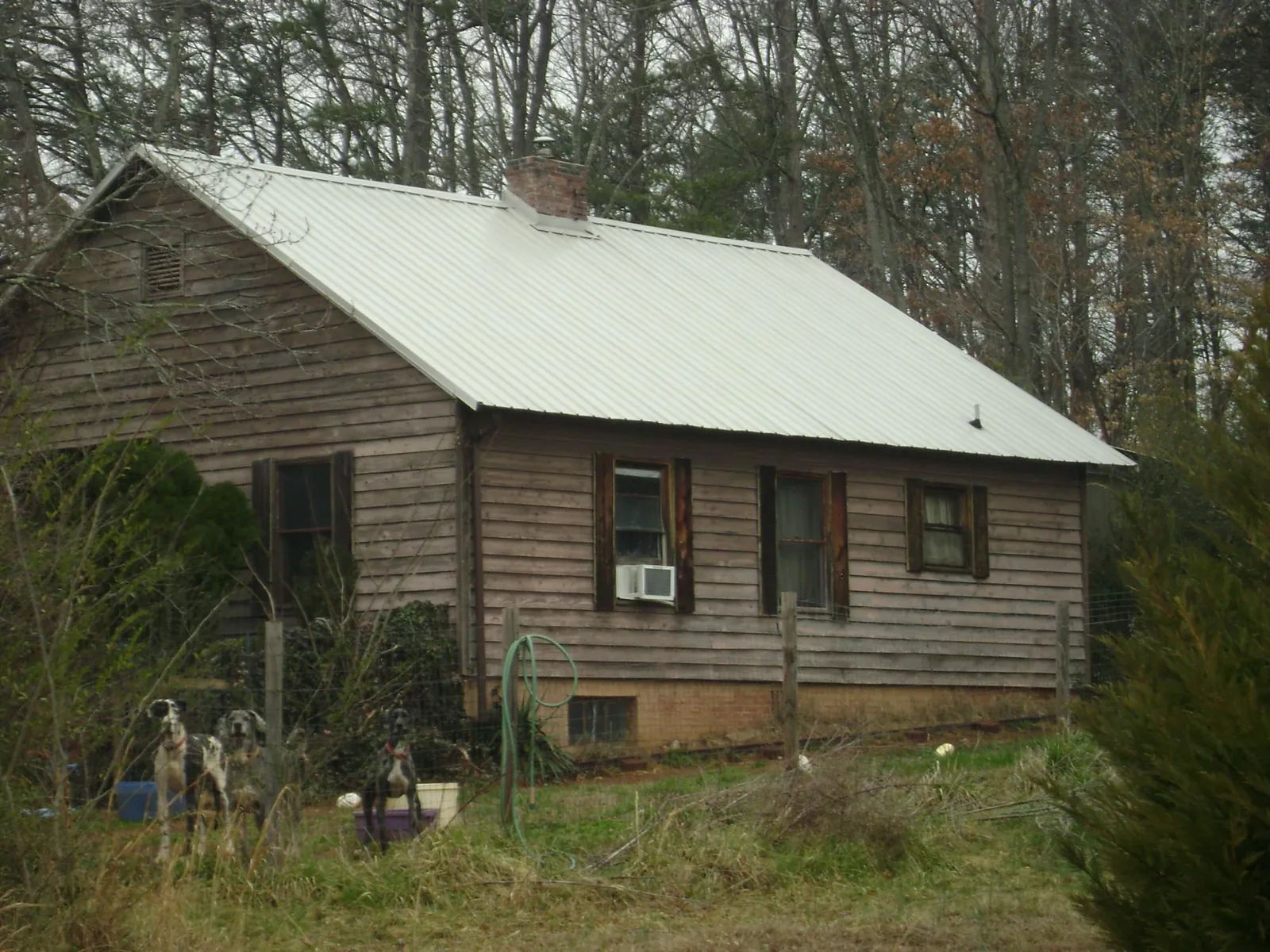 White metal roof on an old wood sided farmhouse, from a Metal Roof Installation job in Cashiers